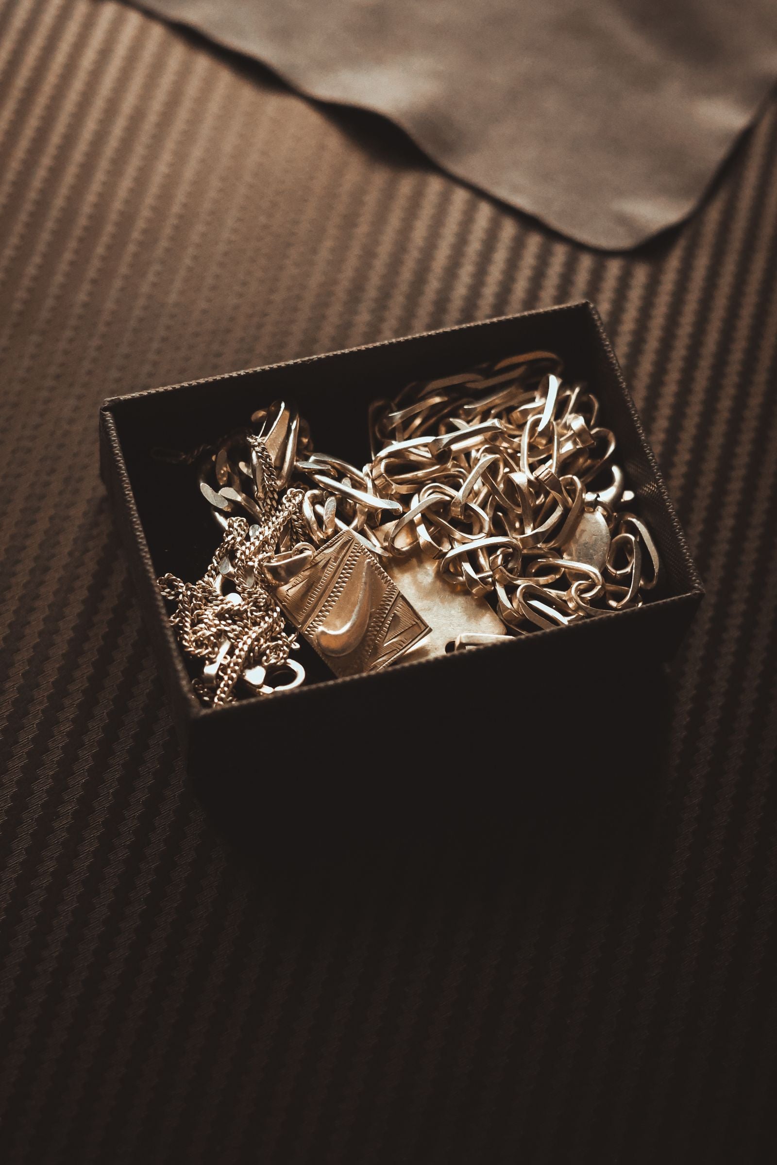 A box of old gold jewellery and chains